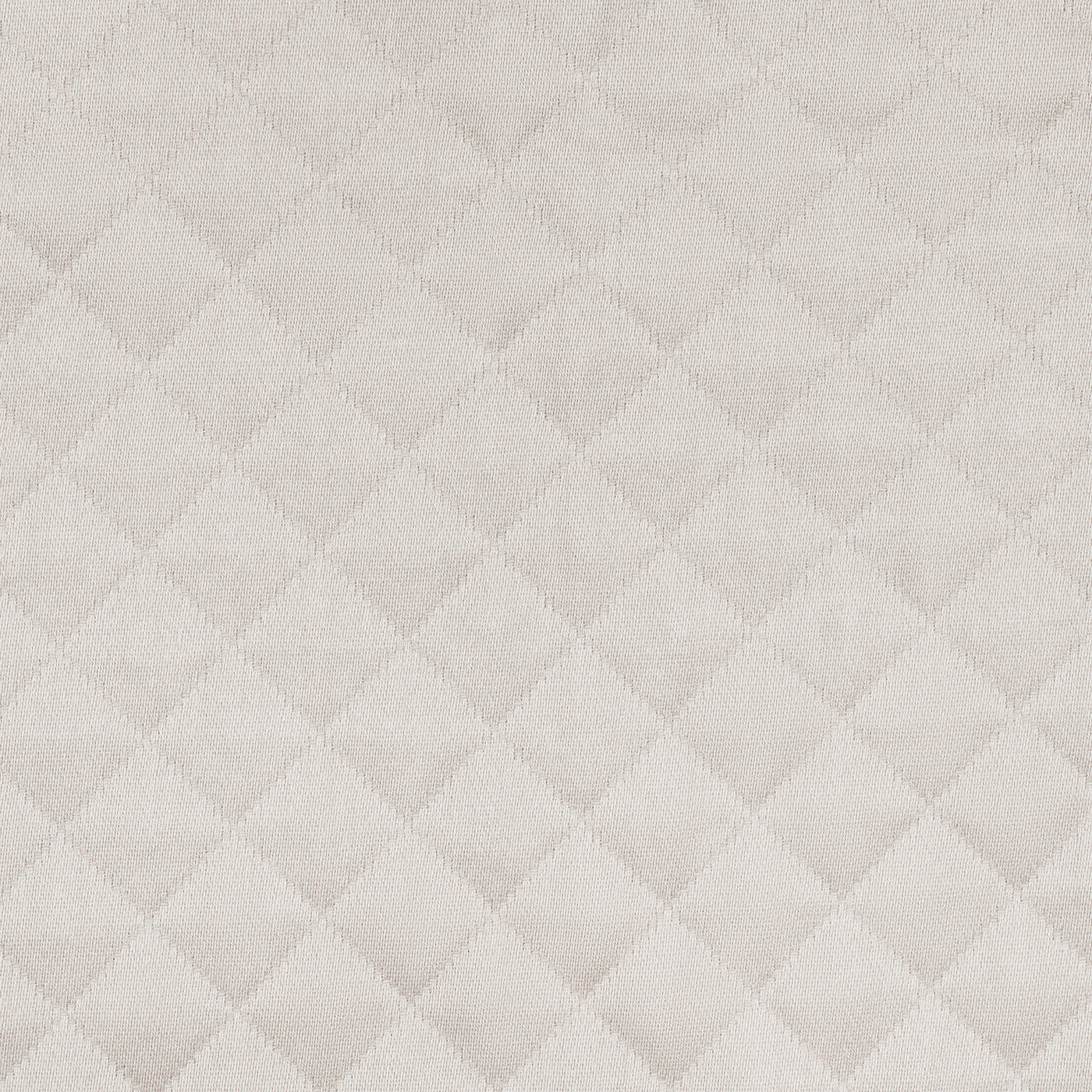 Close-up of Matouk Petra coverlet showing ivory diamond quilted texture.