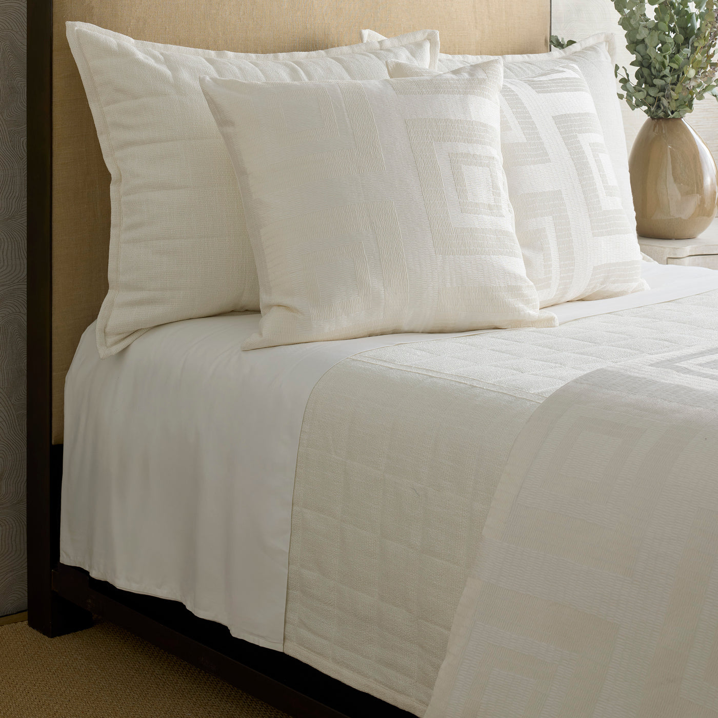 Close-up of Ann Gish Piastrella duvet cover in ivory with quilted diamond stitching on styled bed.