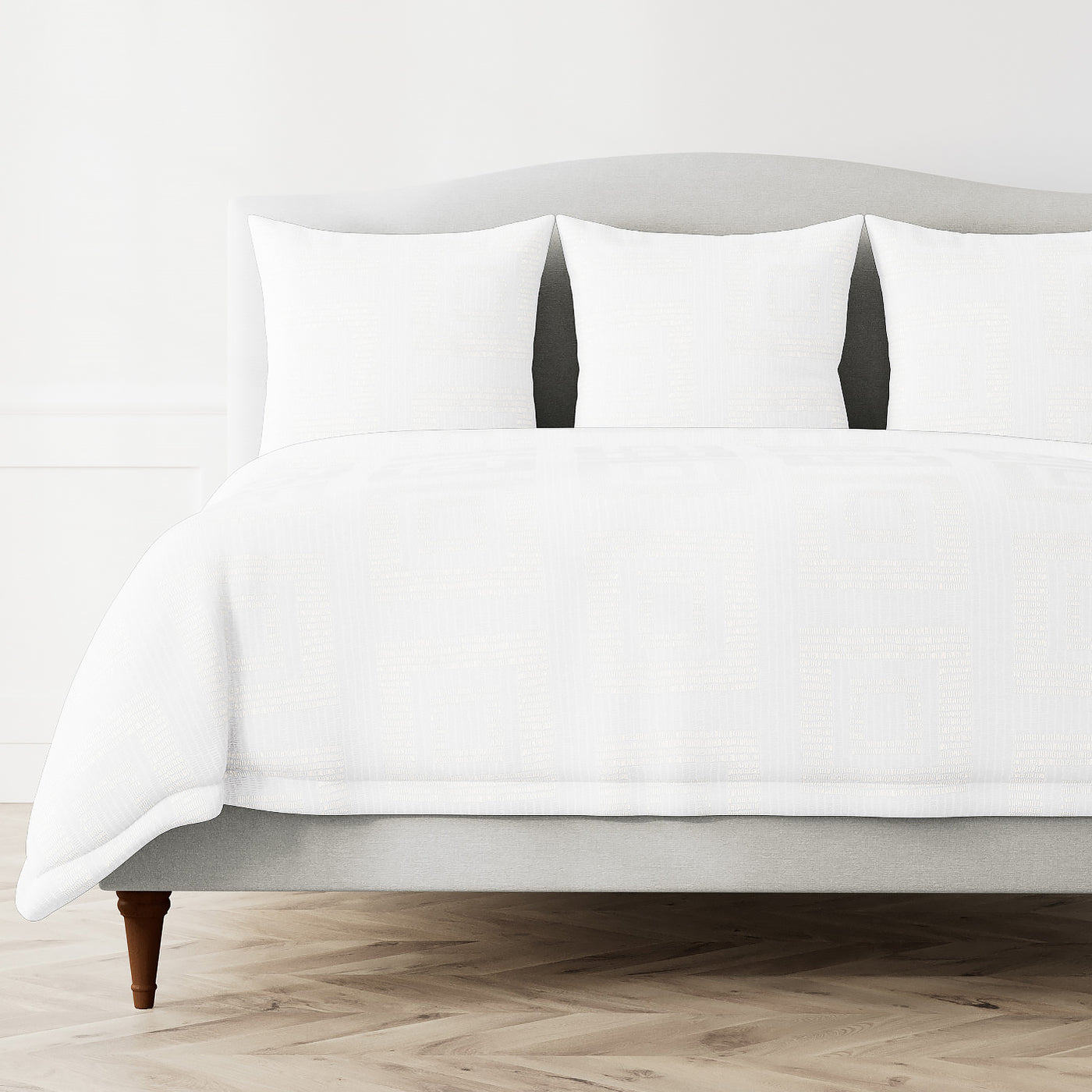 Ann Gish Piastrella duvet cover in white, styled on a full bed with matching shams.