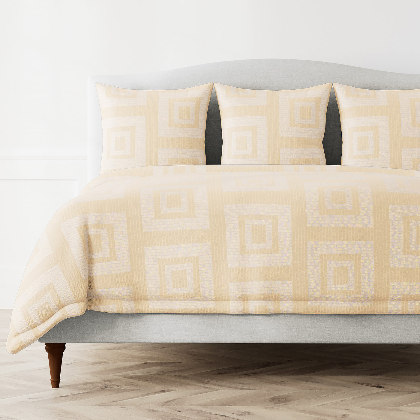 Ann Gish Piastrella duvet cover in champagne, geometric square pattern on styled bed.