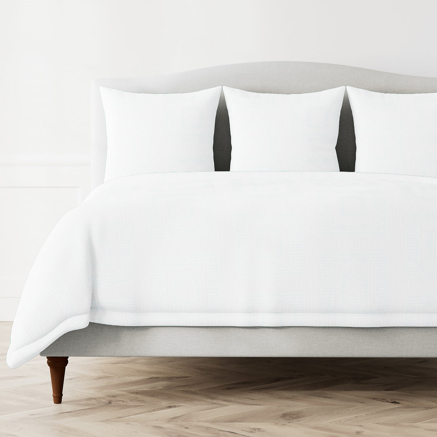 Ann Gish Piastrella duvet cover in white styled on a full bed with matching shams.