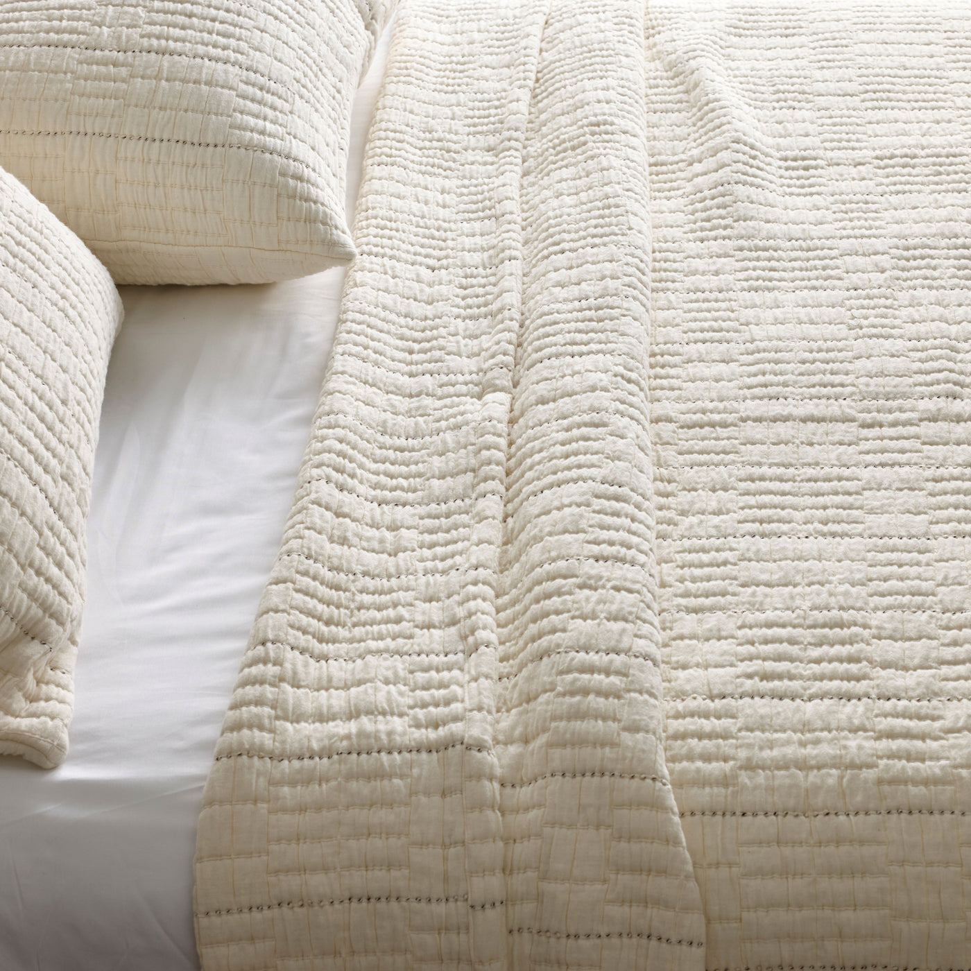 Close-up of ivory Ann Gish Pickstitch coverlet showing textured horizontal stitching detail.