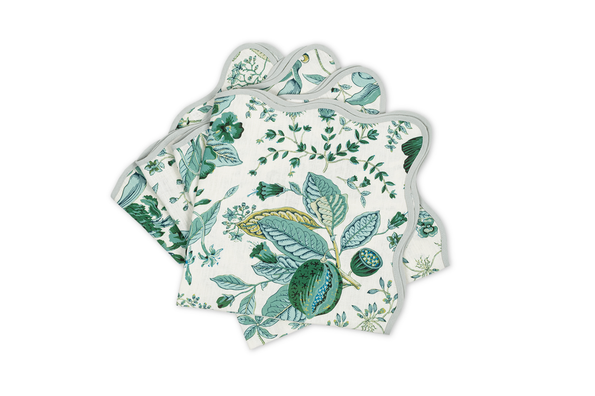 The Matouk Pomegranate Linen | Napkin Set features four scalloped-edge napkins with a green and blue botanical print, perfect for pairing with floral table linens or a Schumacher Pomegranate linen tablecloth.