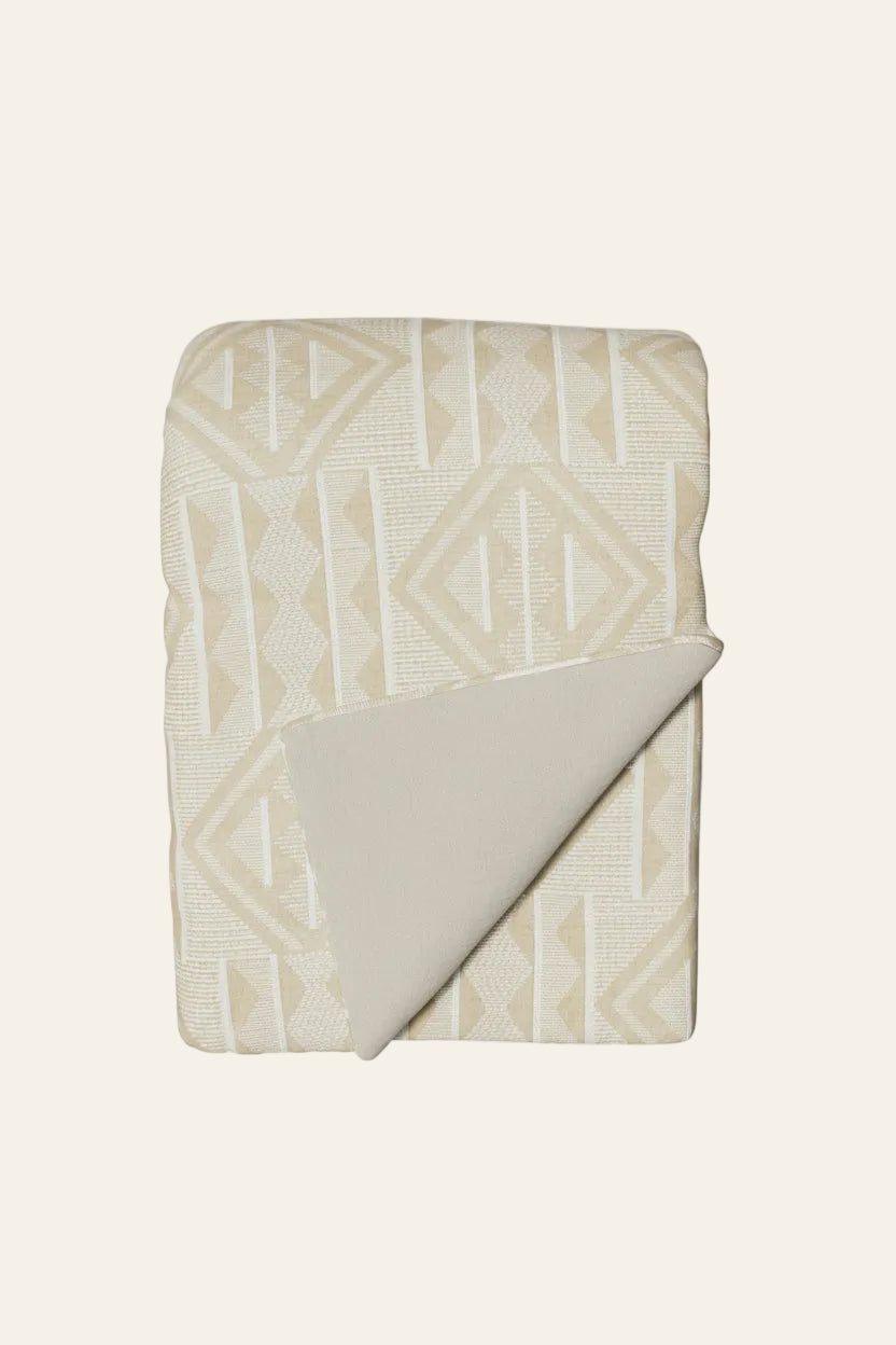 Ann Gish Prestige throw in ivory and champagne geometric jacquard pattern, folded flat.