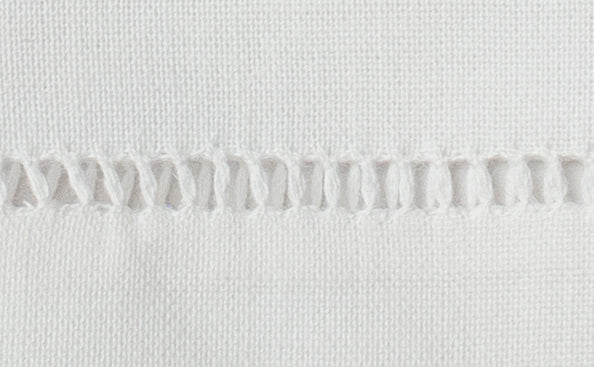 Close-up of handstitched ladder hemstitch border on white cotton napkin.