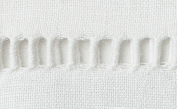 Close-up of ivory linen with hand-stitched ladder hemstitch border detail.