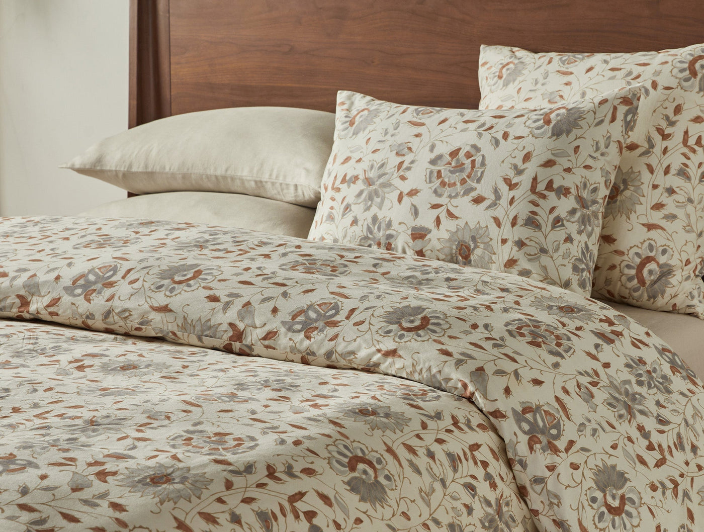 Close-up of Coyuchi Flora Print sham in rust and sage floral pattern on ivory ground.