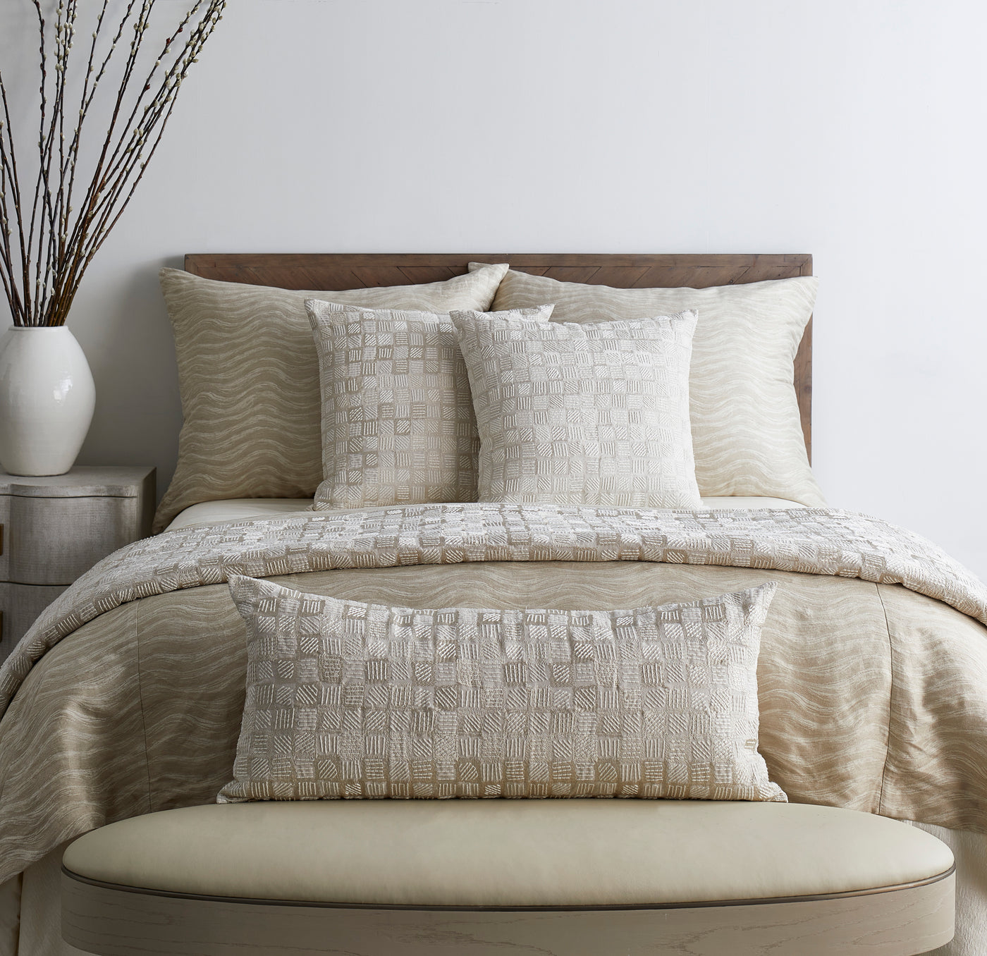 Ivory textured block-pattern lumbar pillow styled on a neutral bedroom bench.