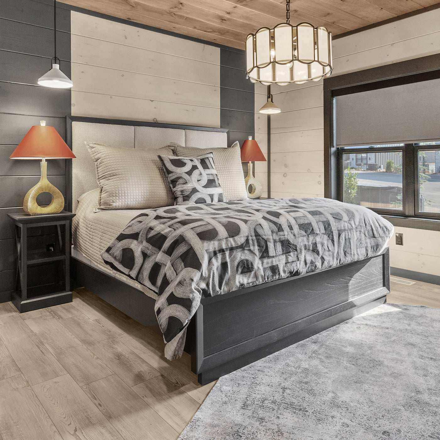 Charcoal and ivory geometric print duvet and pillows styled on a bed in a modern rustic bedroom.
