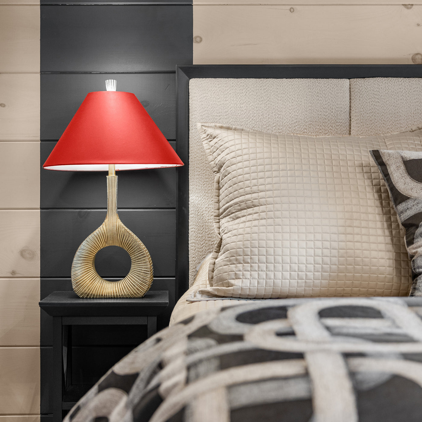 Quilted champagne euro pillow styled on bed with patterned bedding in a dark-paneled bedroom.