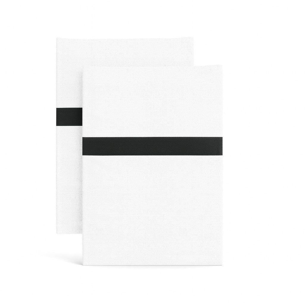 Two white cotton pillowcases with bold black trim stripe, folded flat against white background.