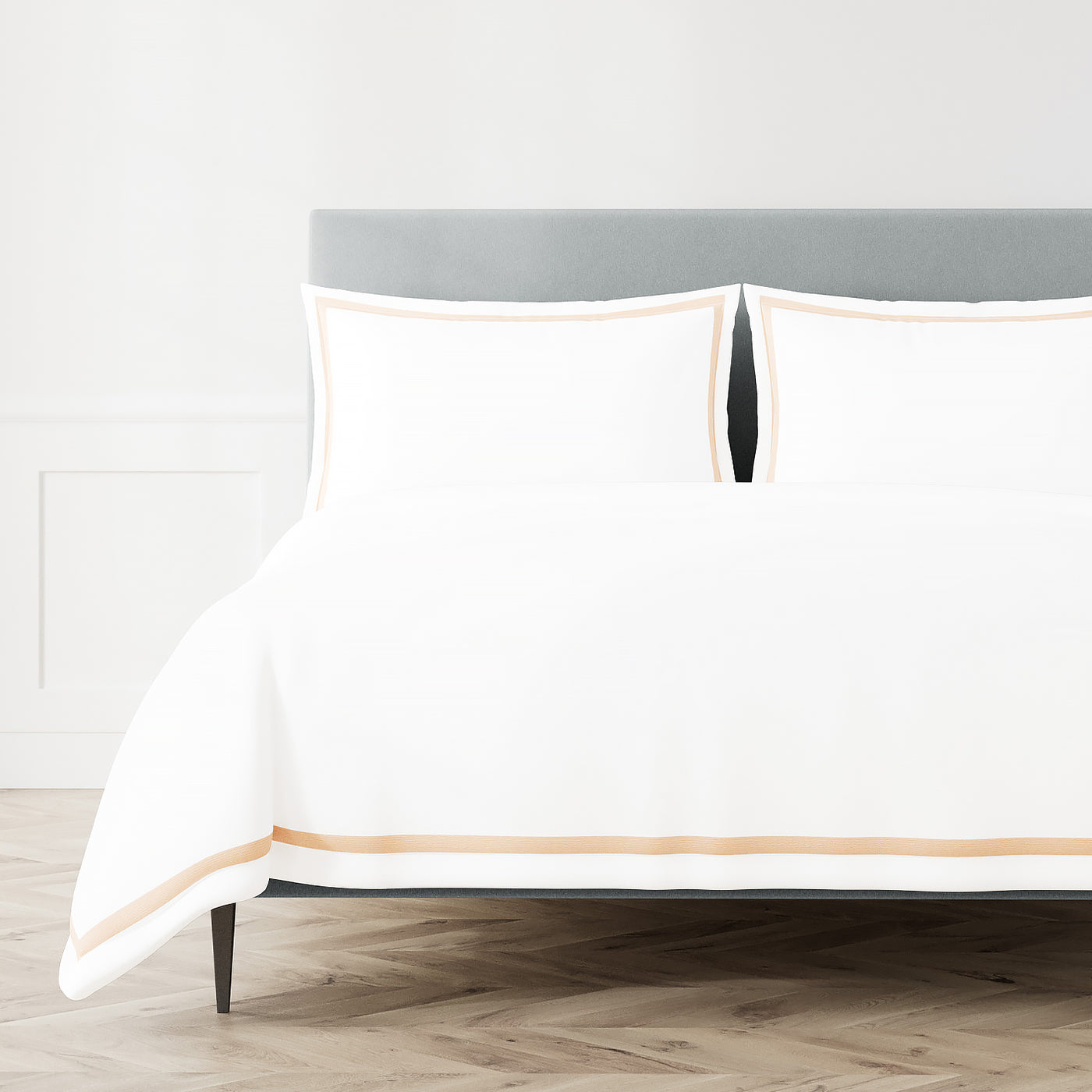 White duvet and shams with champagne double-stripe trim on a styled bed.