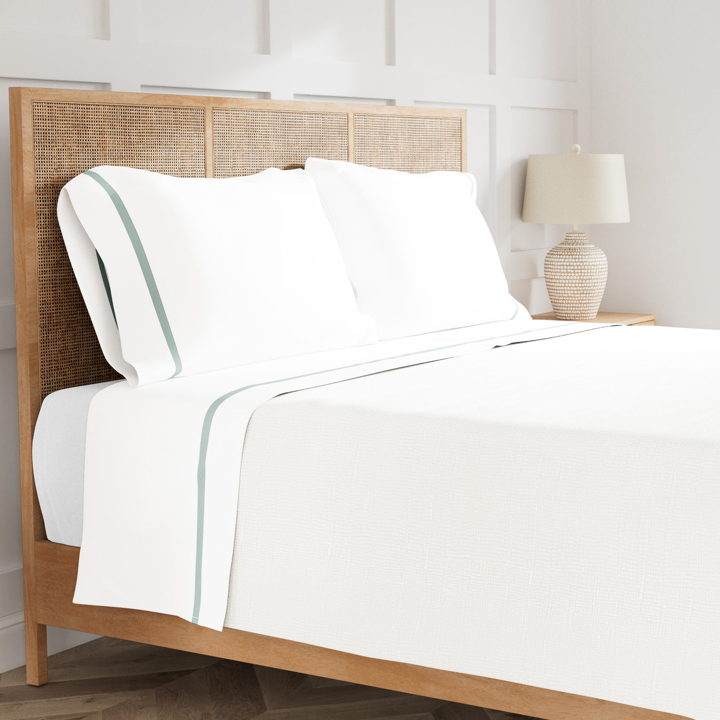 Ann Gish Ready-to-Bed 2.0 white cotton sheet set with sage trim on bed.