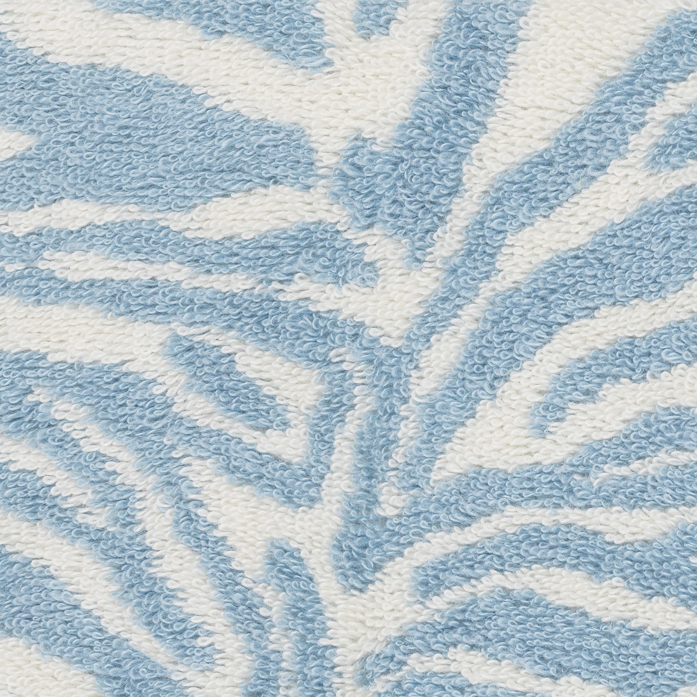 Close-up of Matouk's Regine Wash Cloth, featuring a textured linen-cotton blend with a blue and white zebra stripe pattern.