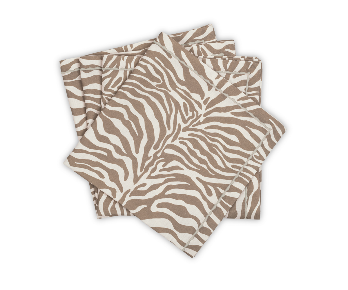 Four folded Regine napkins from Matouk, featuring a brown and white zebra motif, are stacked on a white background.