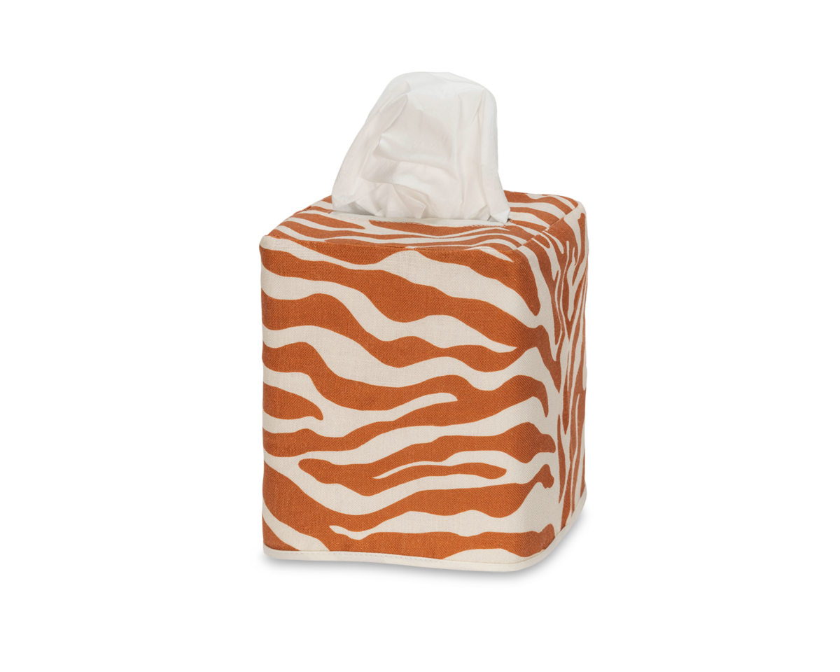 The Matouk Regine | Linen Jacquard Tissue Box Cover is a square box featuring an orange and white zebra motif, with one tissue visible at the top.