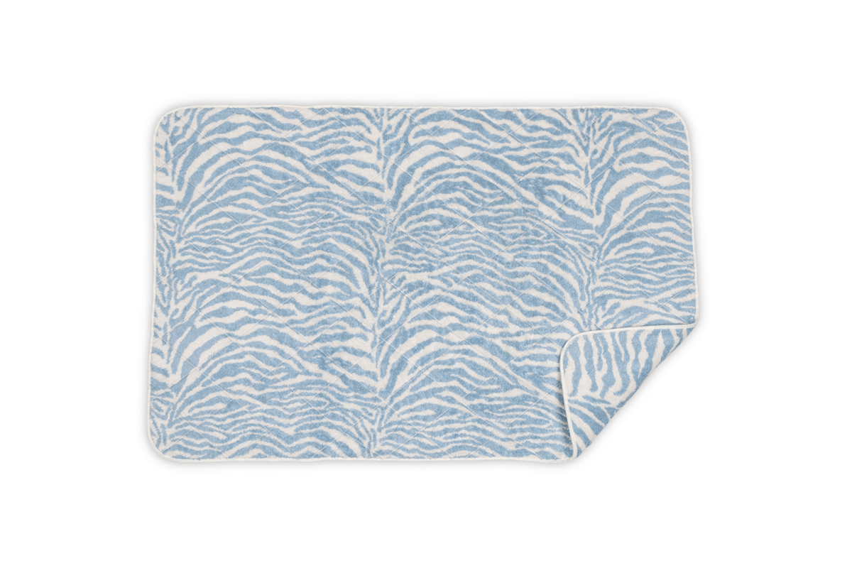 The Regine Quilted Tub Mat by Matouk features a rectangular design with a quilted texture, showcased with one corner folded over.