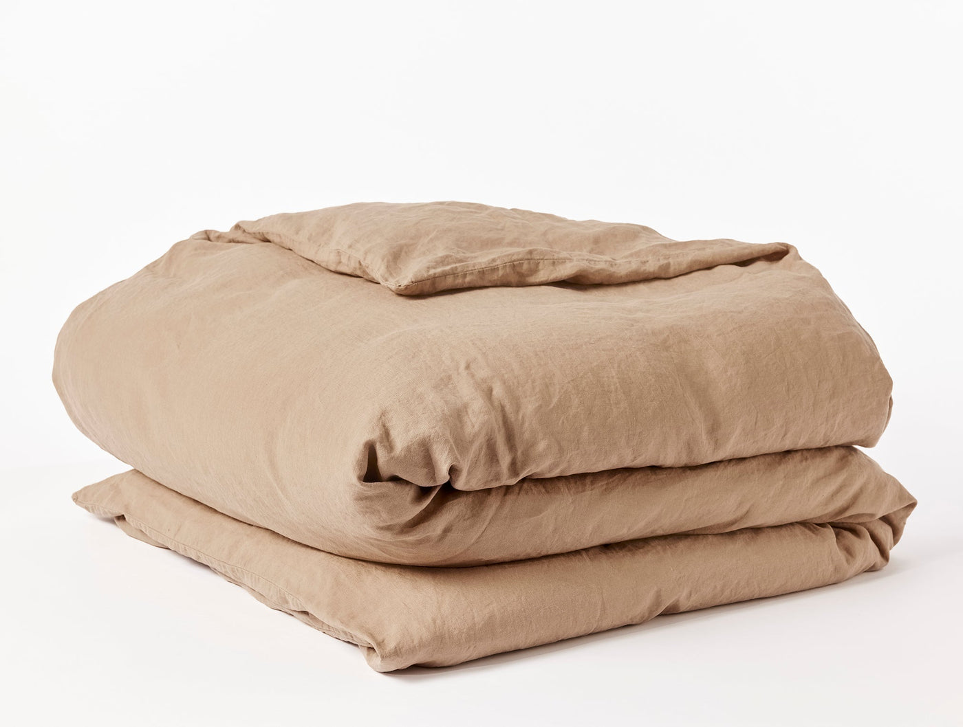 Coyuchi Relaxed Linen duvet cover folded in warm camel, showing casual linen texture.
