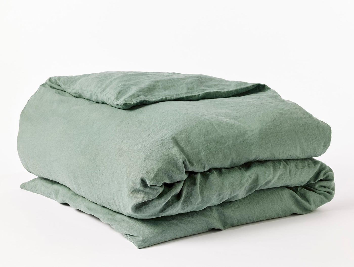 Coyuchi Relaxed Linen duvet cover folded, showing sage green washed linen texture.