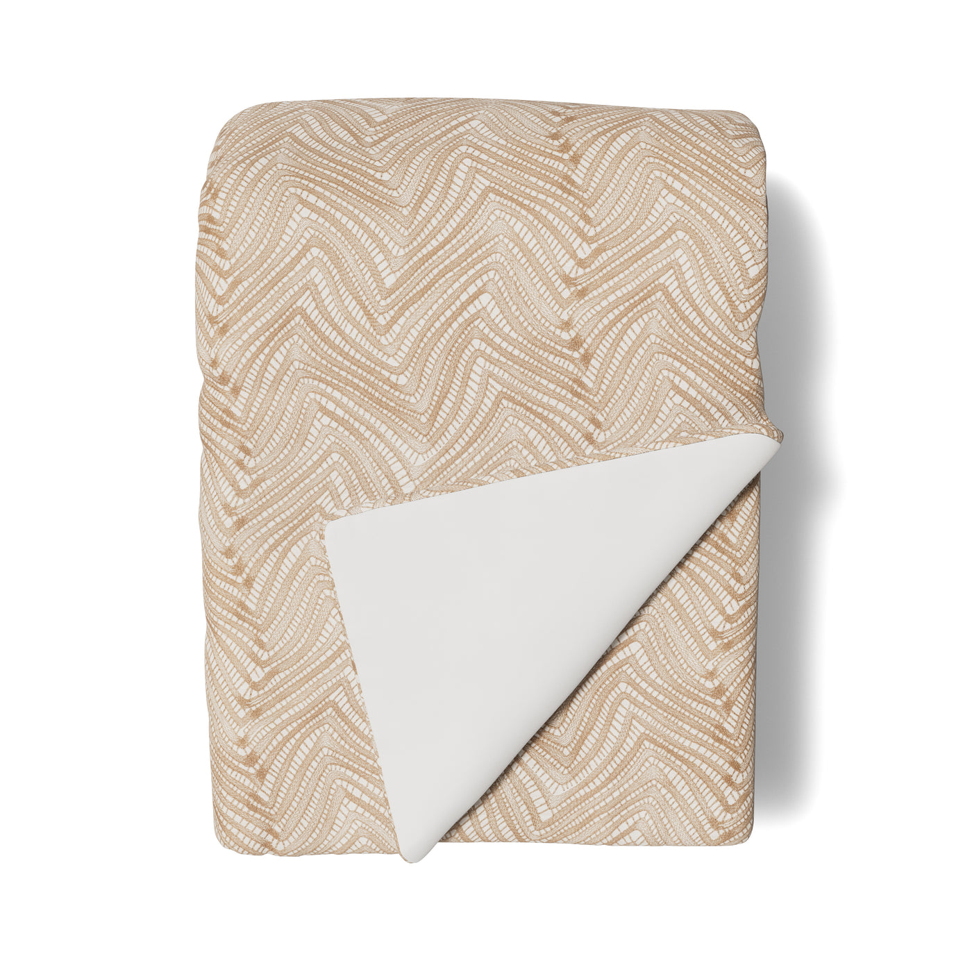 Folded Ann Gish Retortoli throw, sand chevron weave pattern with ivory reverse.