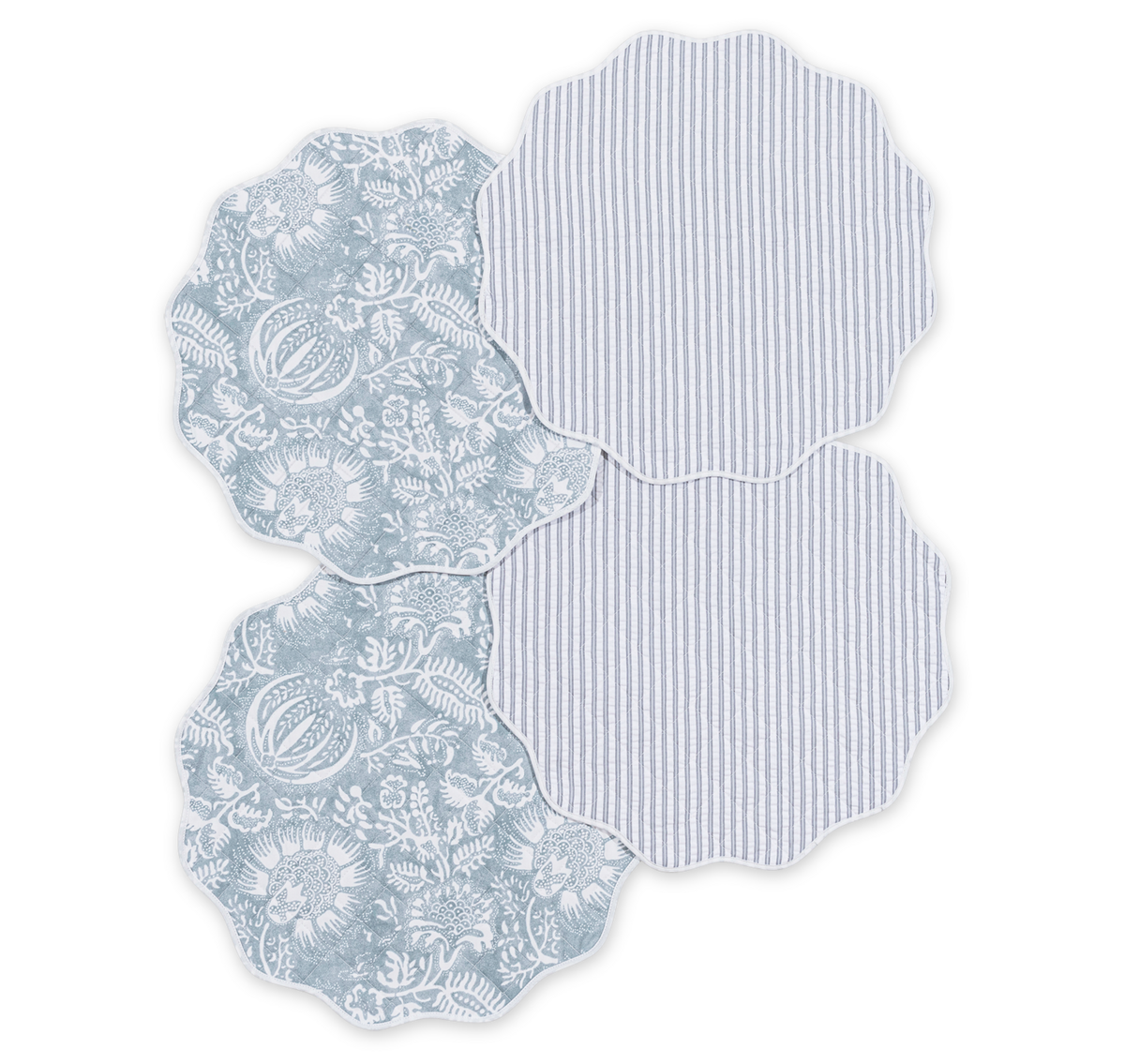 The Matouk Quilted Reversible Placemat Set includes four scalloped-edge placemats—two in blue floral and two in blue and white stripes—ideal for adding a stylish touch to your dining table.