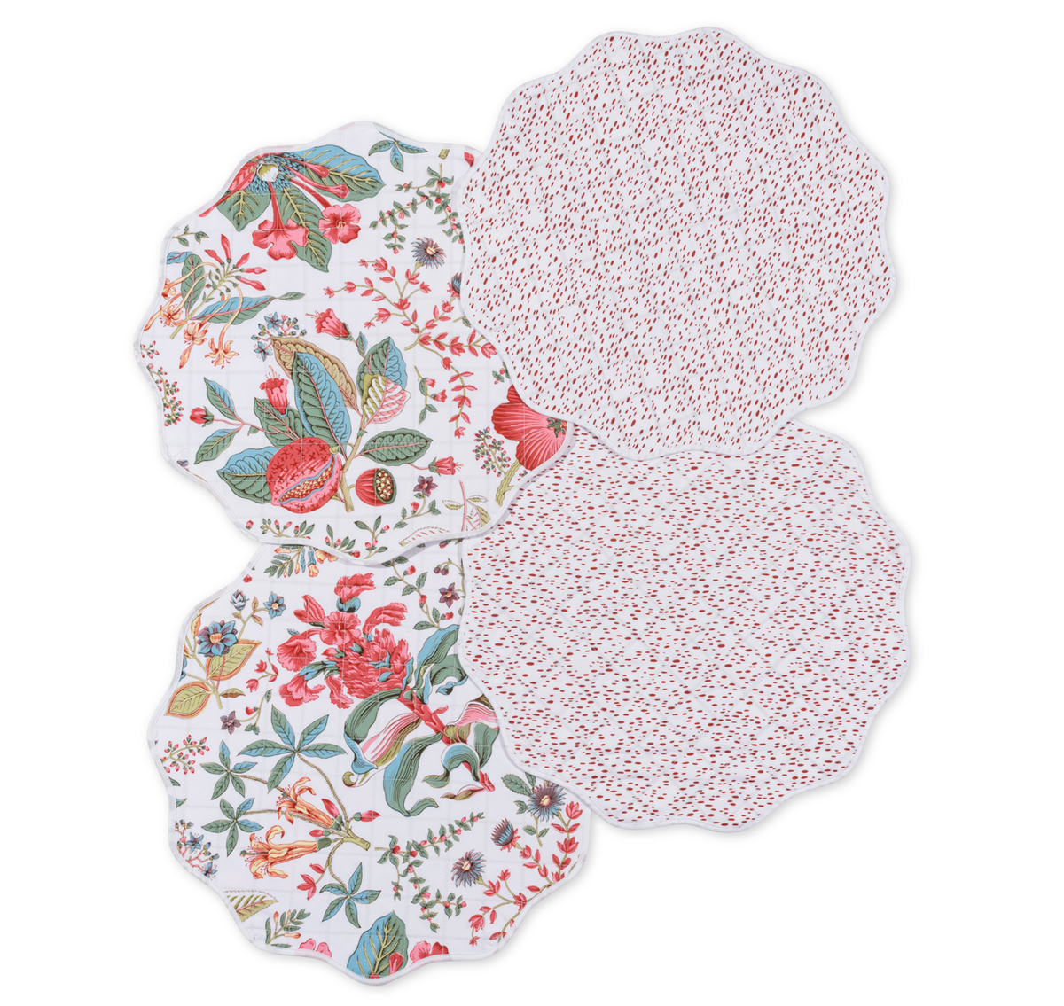 Elevate your dining table decor by pairing Matouk’s Quilted Reversible Placemat Set with a mix of scalloped-edge plates featuring botanical or red dotted designs.