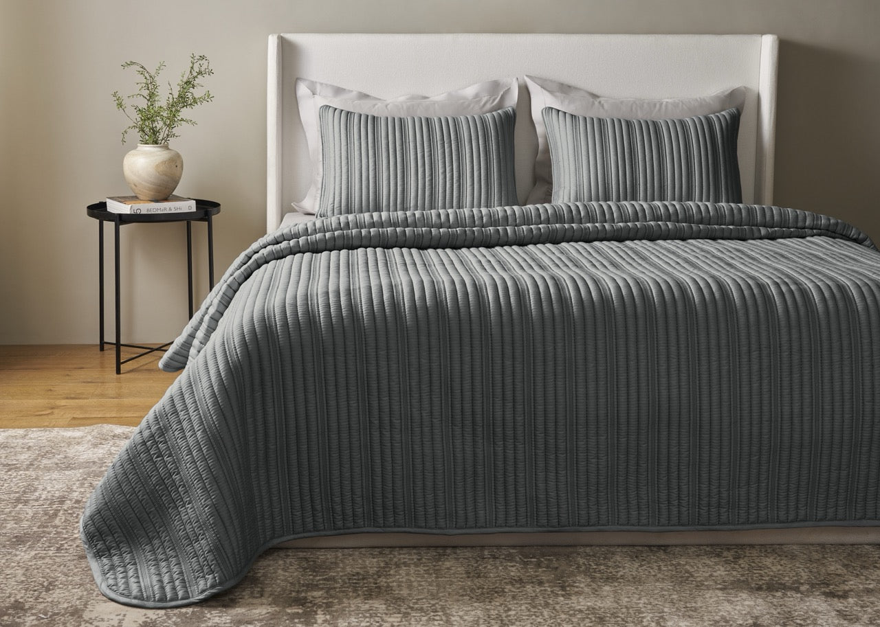 Ann Gish Rib coverlet set in slate grey, styled on a full bed with matching shams.