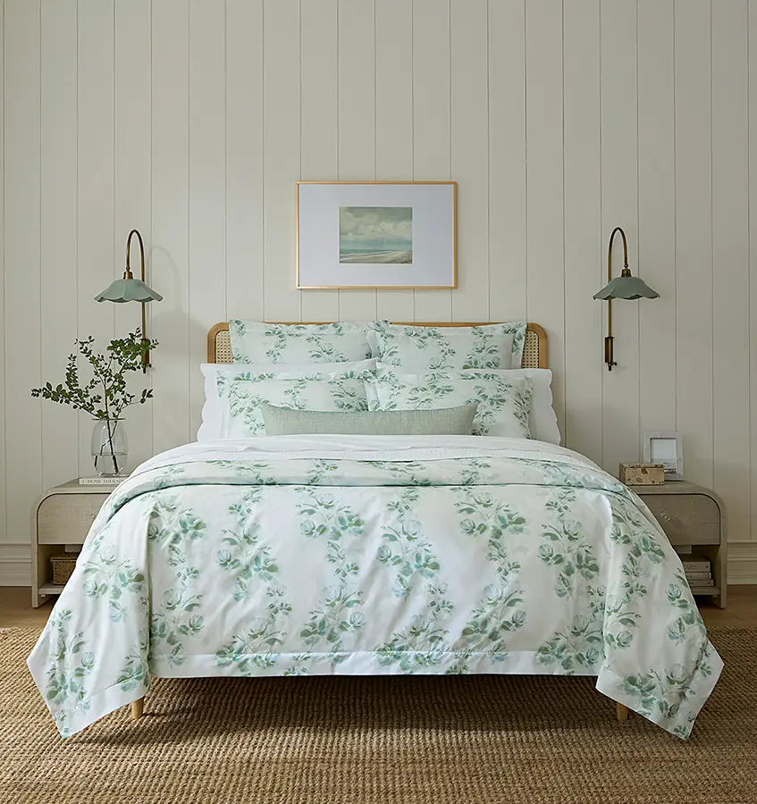 Sferra Rosa duvet cover in sage floral print styled on a rattan bed with matching shams.