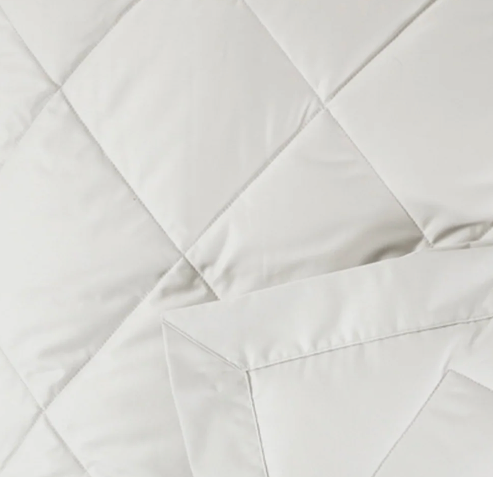 Close-up of ivory quilted diamond stitching on Scandia Home down robe fabric.