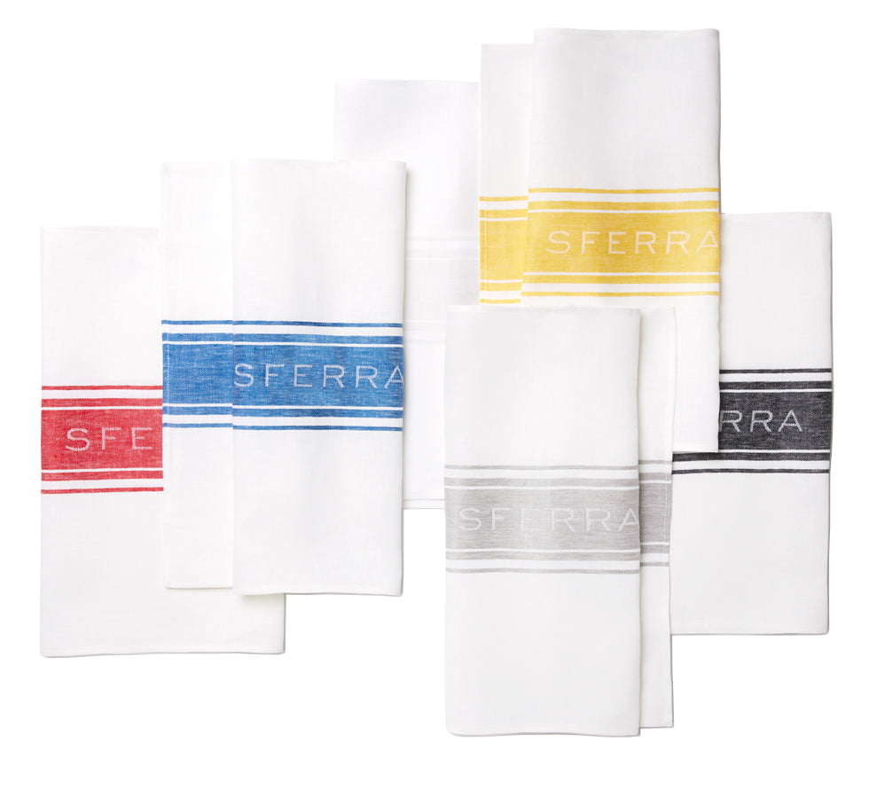 Sferra Parma kitchen towels in white with red, blue, yellow, grey, and black stripe borders.