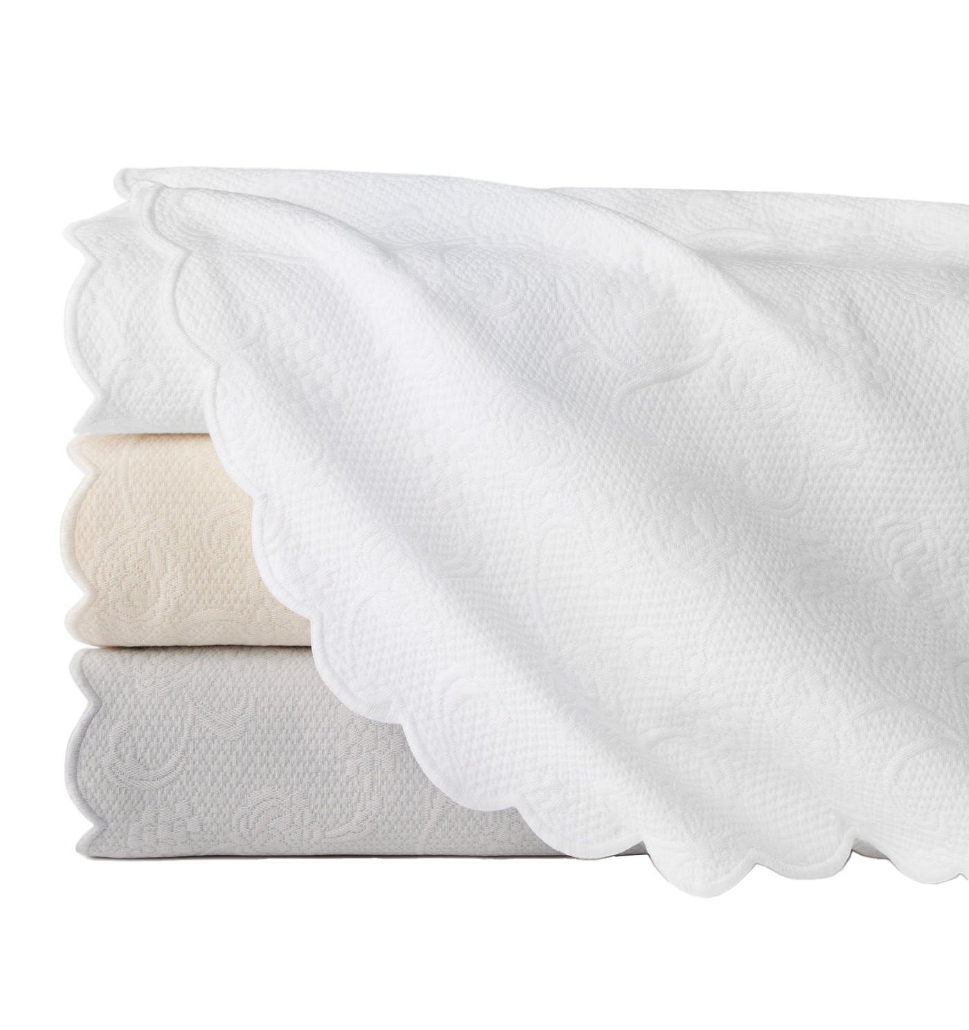 Sferra Alice coverlets stacked in white and ivory, with scalloped edges and floral matelassé weave.