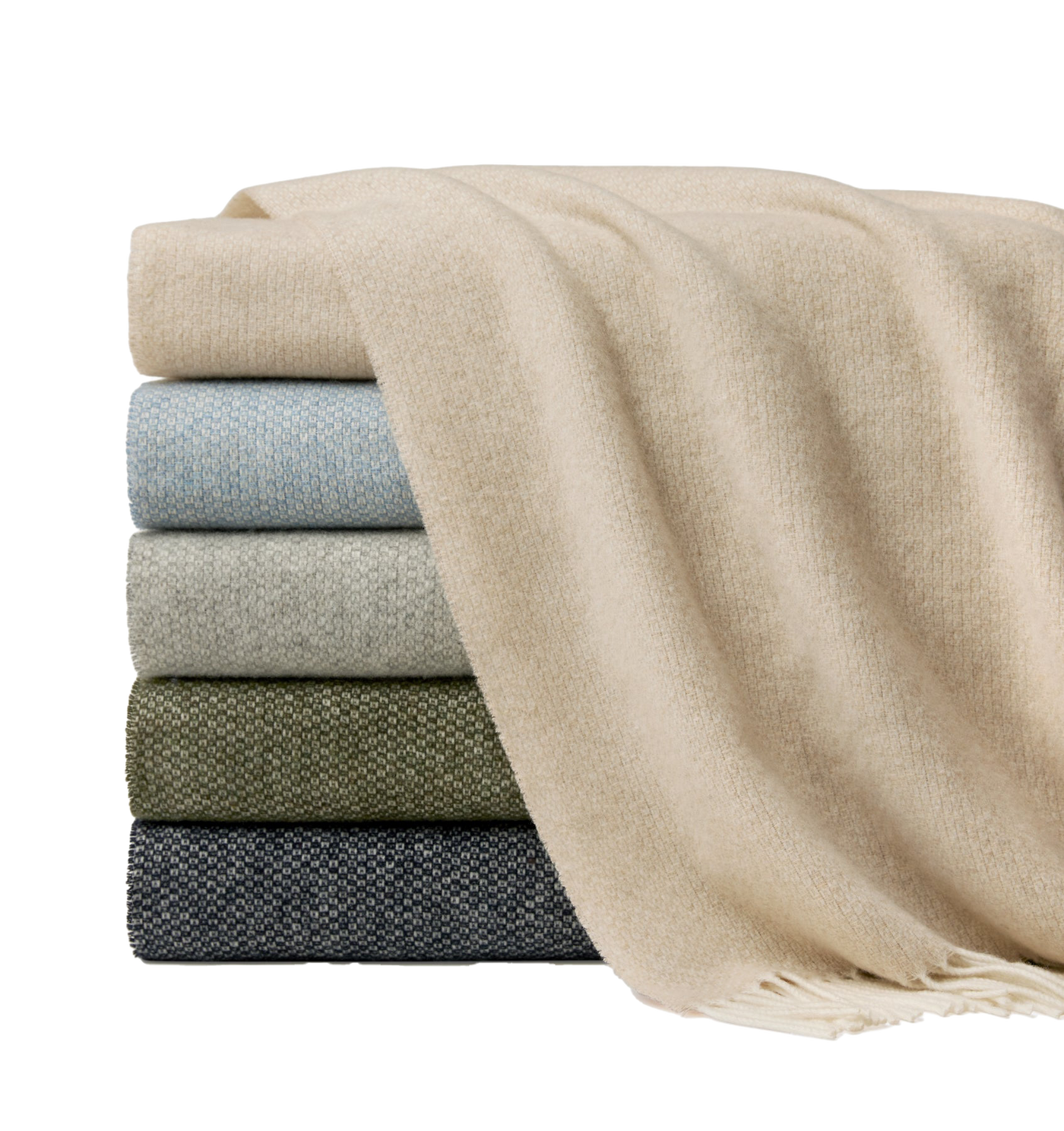 Sferra Cervino throw in oatmeal draped over stacked throws in sage, olive, and charcoal.