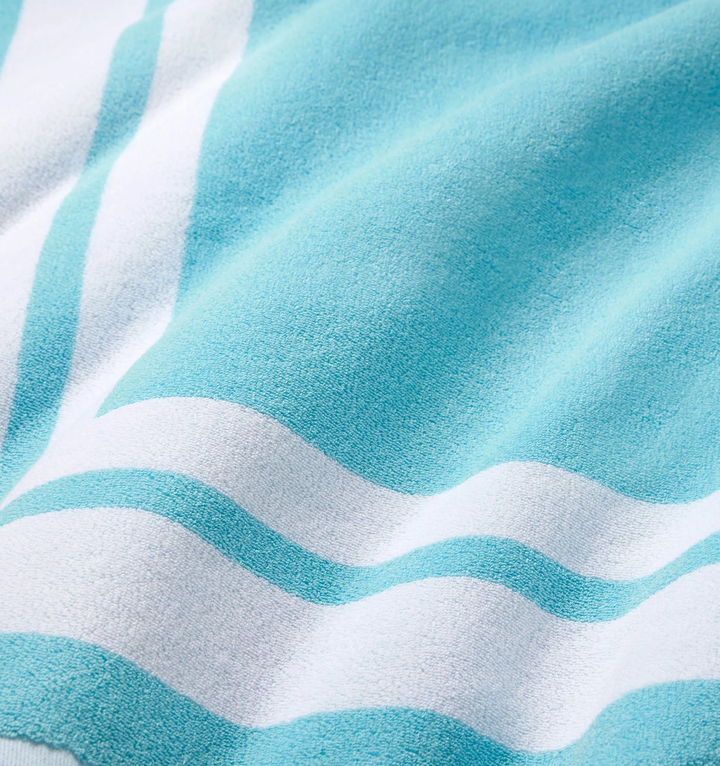 Close-up of aqua and white striped terry cloth texture on the Sferra Mareta beach towel.