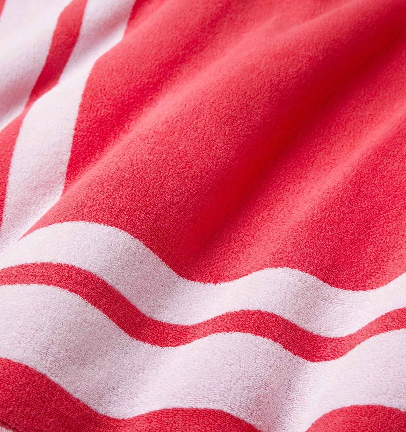 Close-up of coral and white stripe terry weave texture on Sferra Mareta beach towel.