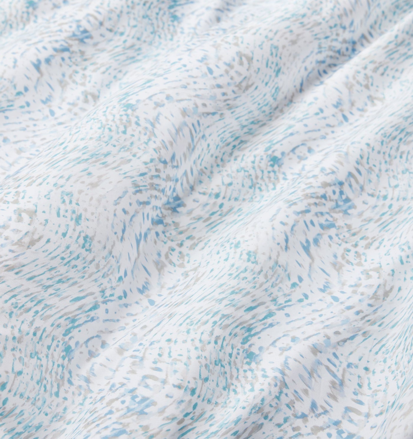 Close-up of Sferra Meloria fabric showing aqua and white watercolor-style print on crisp cotton.
