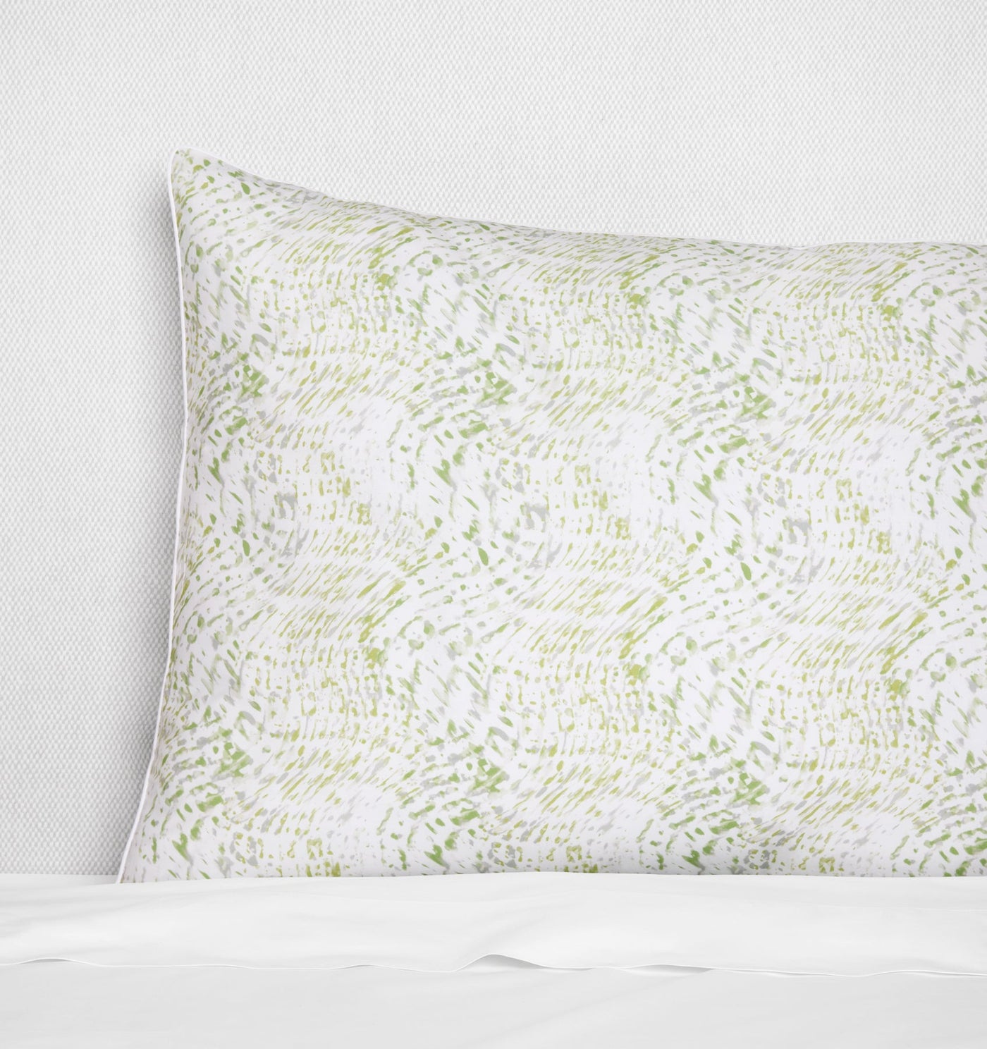 Side-angle view of Sferra Meloria sham with sage green abstract print on white cotton.