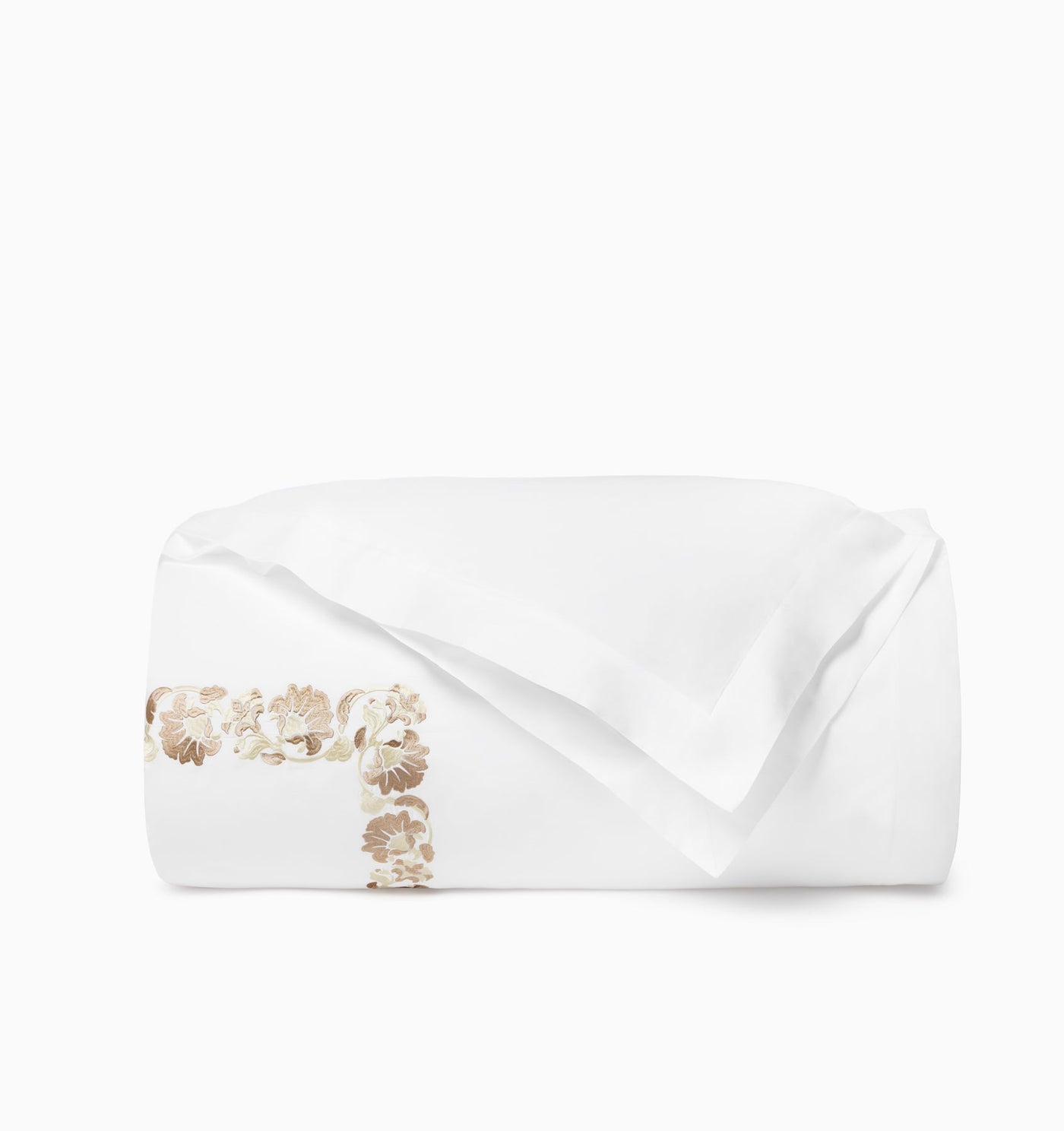 Folded white duvet cover showing champagne floral embroidered border detail.