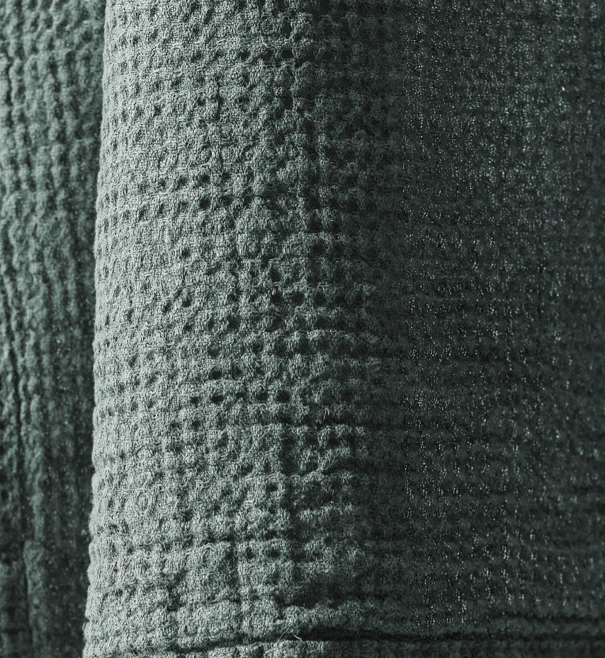 Close-up of sage green waffle-weave cotton texture on a Society Limonta robe.