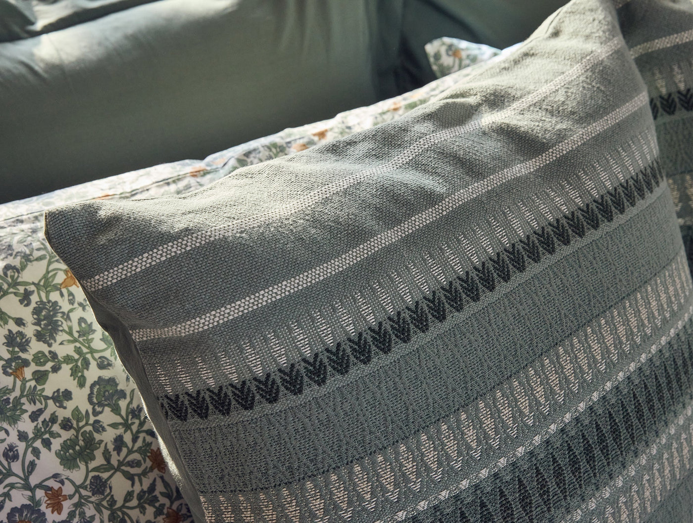 Close-up of Coyuchi Lost Coast pillow's woven stripe and chevron texture detail in slate grey.