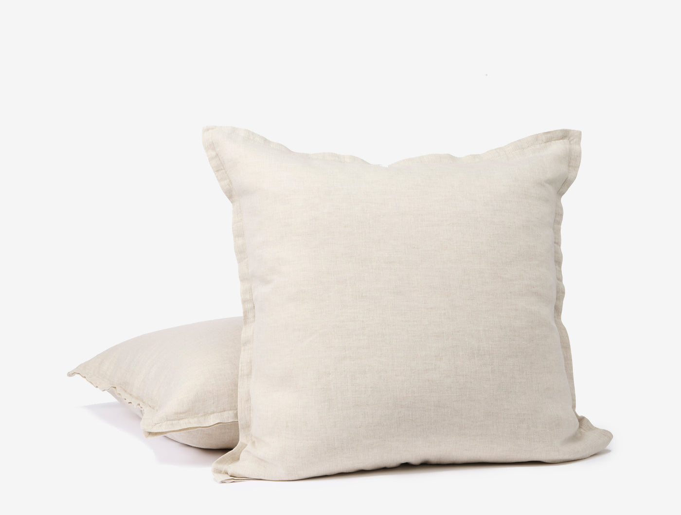 Two Coyuchi Relaxed Linen ivory pillow covers stacked, showing flange edge detail.