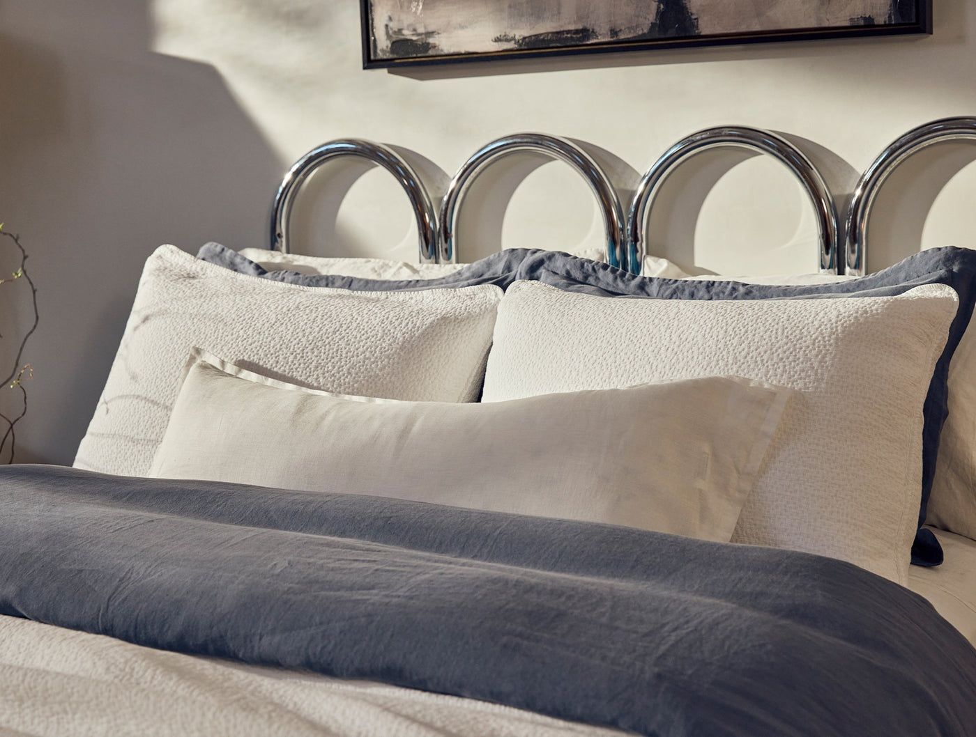 Close-up of ivory Coyuchi Cascade Matelassé sham with textured weave, styled on a made bed.