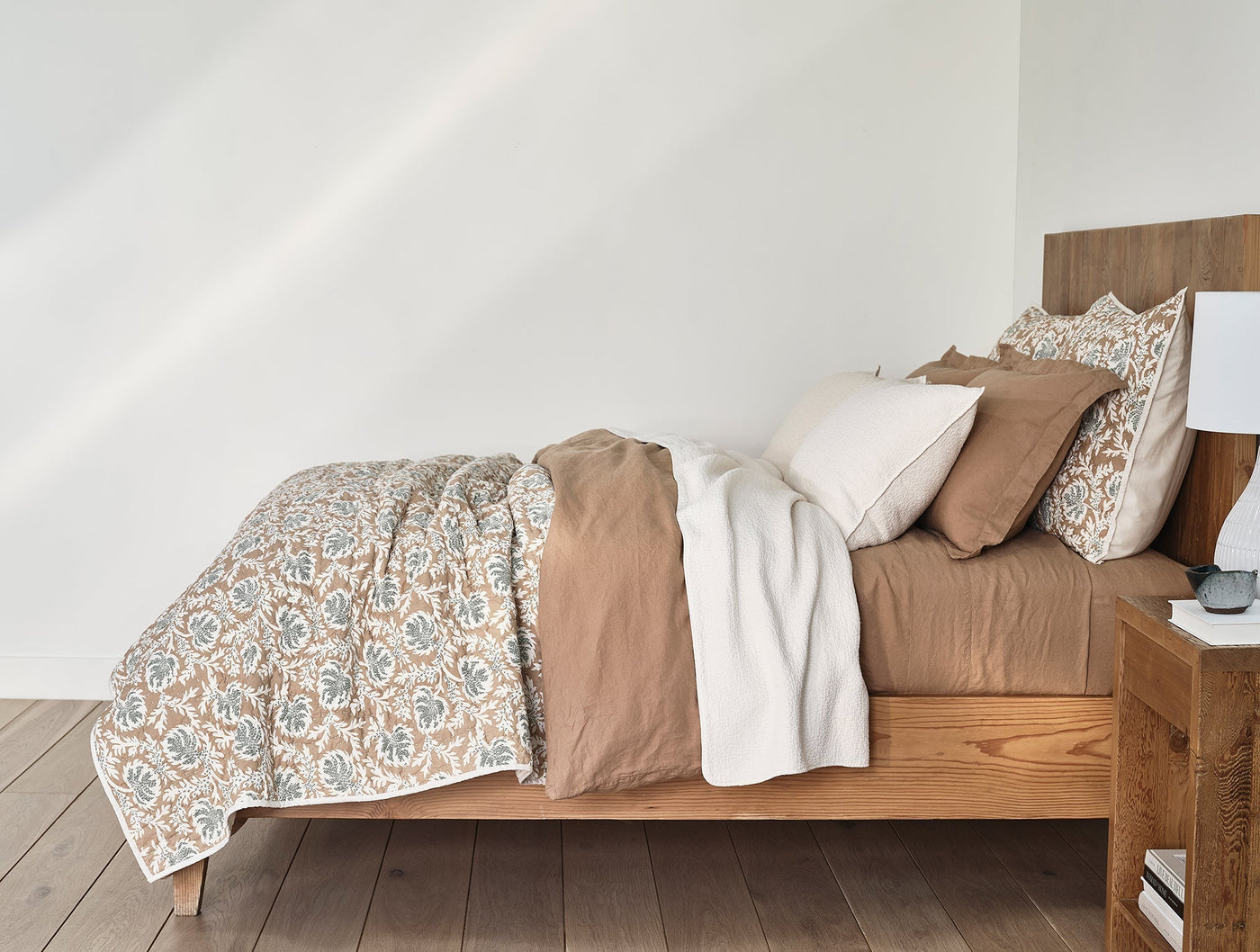 Robles Handstitched sham on a styled bed with floral block-print duvet in ivory and blue.