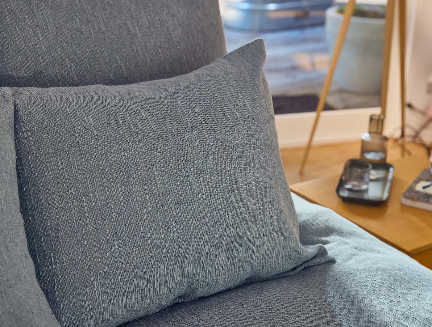 Close-up of Coyuchi Toro Canyon sham in slate blue, showing textured linen weave on a styled chair.