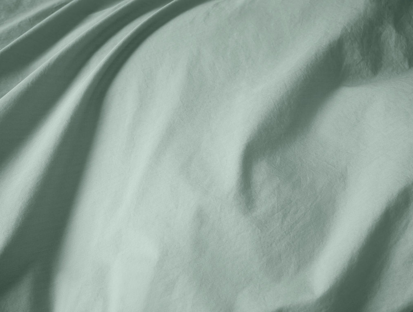 Soft sage green percale fabric with gentle draping and natural shadow detail.