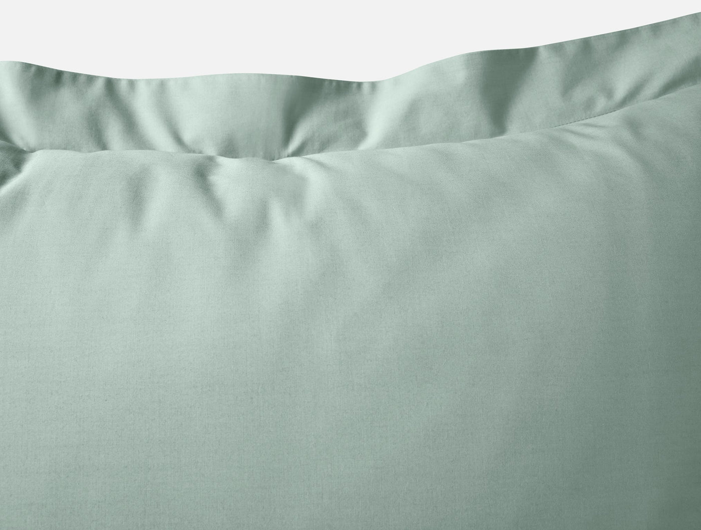Close-up of sage Coyuchi Refined Percale pillow sham showing crisp percale weave and envelope edge.