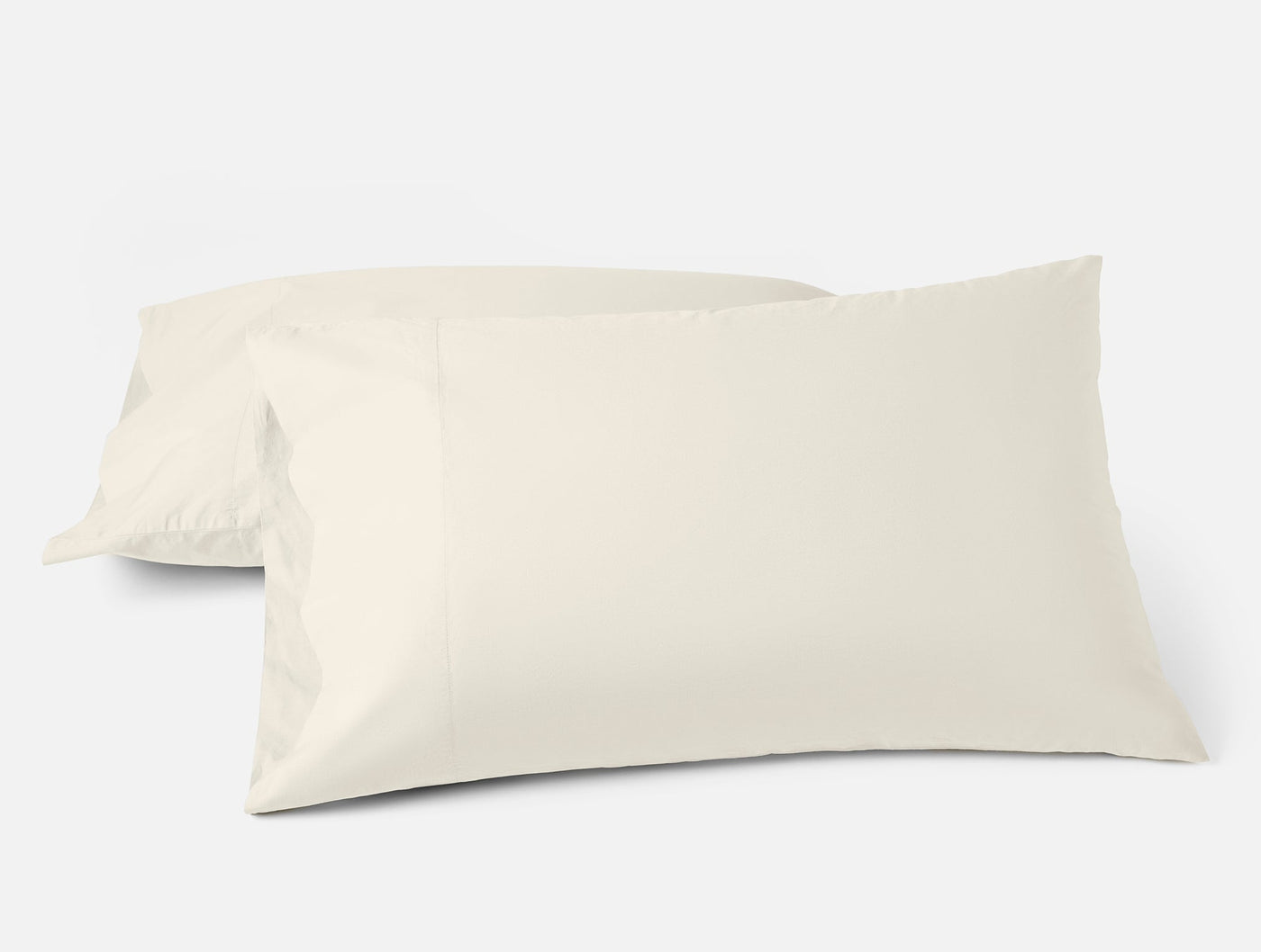 Two ivory Coyuchi Refined Percale pillowcases, crisp and smooth on white background.
