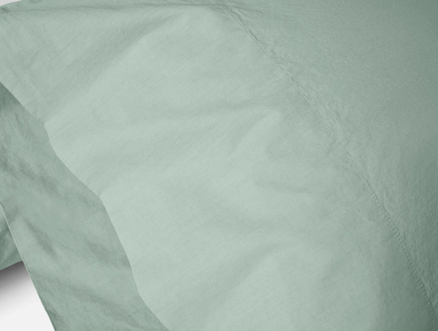 Close-up of Coyuchi Refined Percale pillowcase pair in sage, showing crisp percale weave.
