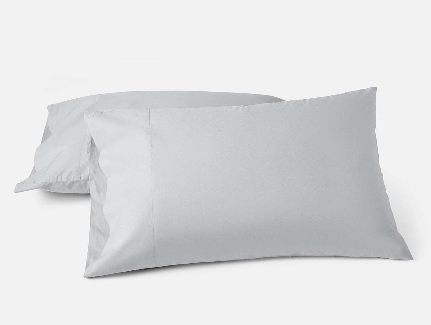 Two Coyuchi Refined Percale pillowcases in silver-grey, stacked and styled against white background.