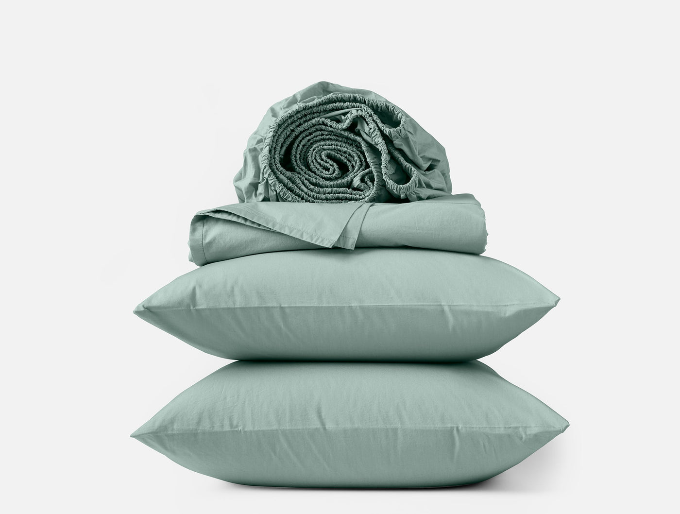 Sage green percale sheet set with stacked pillowcases and rolled sheets on white background.