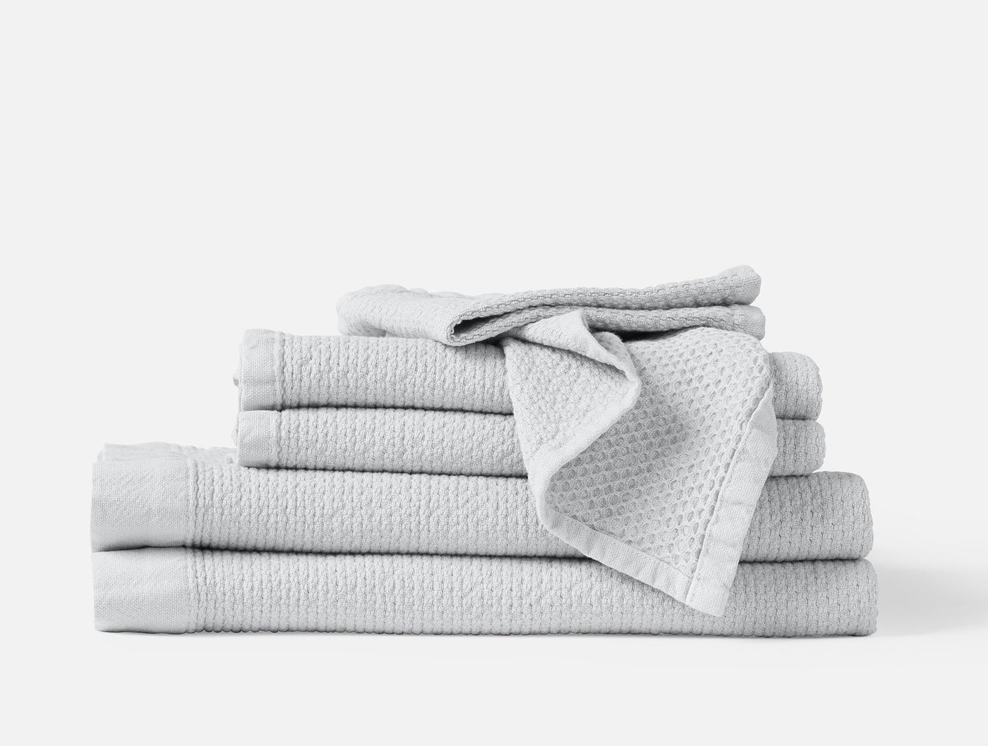 Coyuchi Adriatic towel set stacked in silver, showing waffle-textured weave detail.